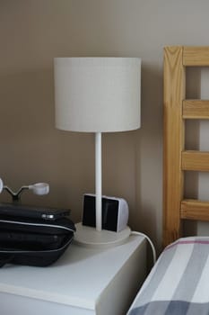 bedside table near bed full of devices lamp wireless charges danger waves insomnia sleep night . High quality photo