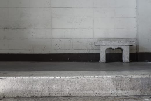 Old concrete texture wall with a old marble bench in front of it. Space for text, Selective Focus.