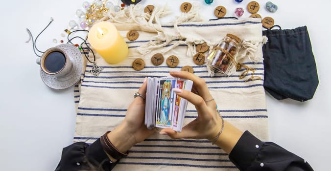 A fortune teller reads with tarot cards. Selective focus. Woman.