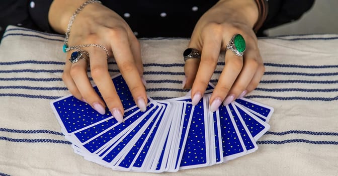 A fortune teller reads with tarot cards. Selective focus. Woman.