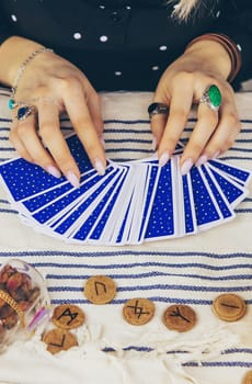A fortune teller reads with tarot cards. Selective focus. Woman.