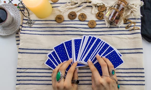 A fortune teller reads with tarot cards. Selective focus. Woman.