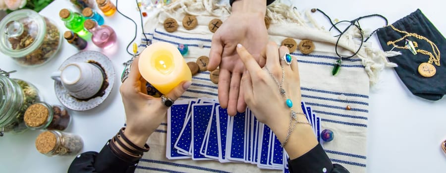 A fortune teller reads with tarot cards. Selective focus. Woman.