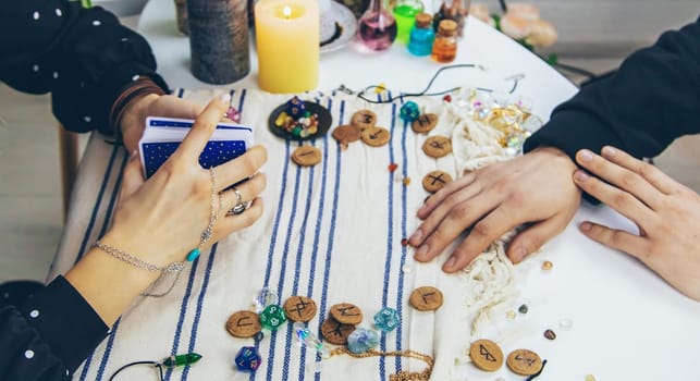 A woman fortuneteller tells a man on tarot cards. Selective focus. People.