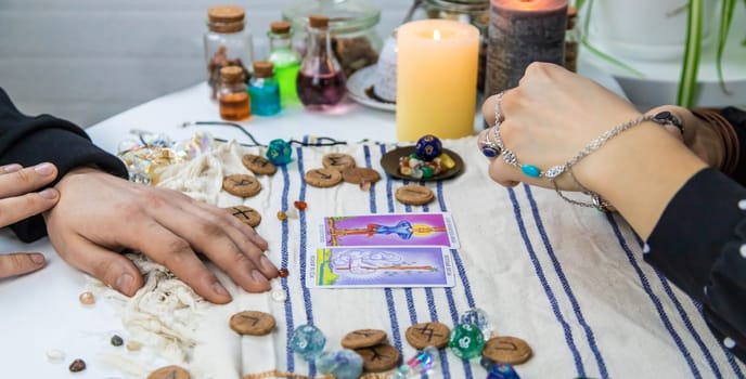 A woman fortuneteller tells a man on tarot cards. Selective focus. People.