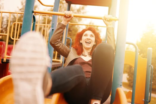 A joyful woman sliding down a colorful playground slide, embodying bliss and happiness in the warm sun
