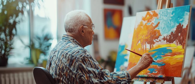 An elderly man passionately creates a vibrant landscape painting on canvas in a bright studio, showcasing his artistic talent and colorful expression.