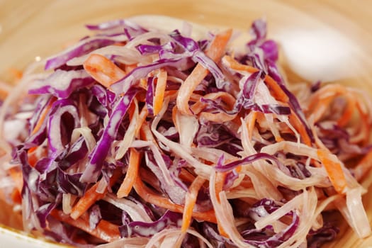 Freshly prepared coleslaw with vibrant purple and orange cabbage served in a rustic bowl, perfect for summer gatherings and picnics