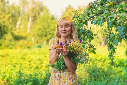 Woman with medicinal herbs in a meadow. Selective focus. nature.
