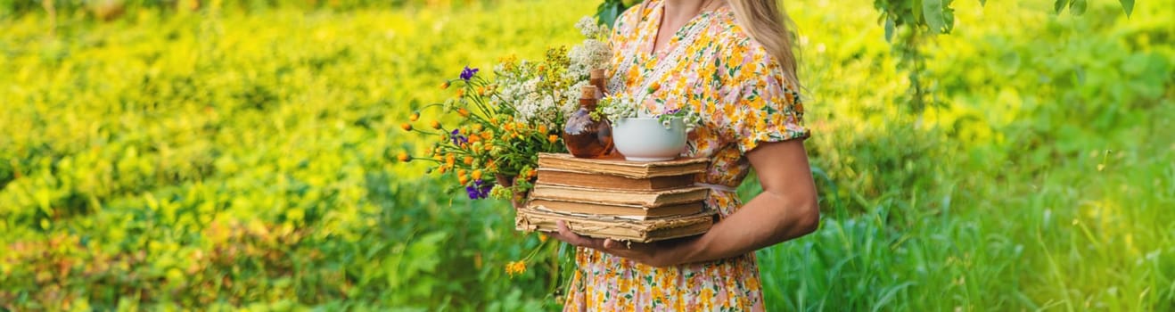 Woman with medicinal herbs in a meadow. Selective focus. nature.