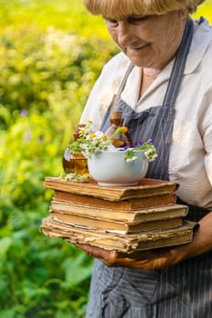 Woman with medicinal herbs in a meadow. Selective focus. nature.