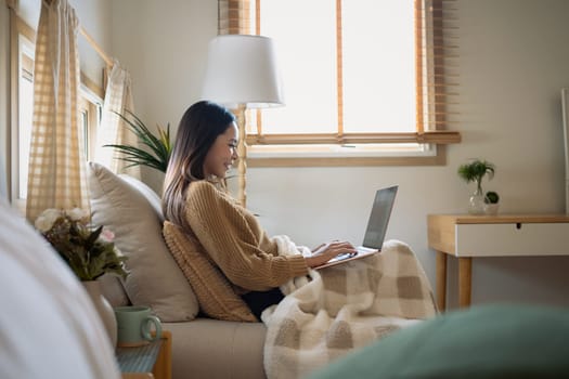 Young woman enjoying work from home in a warm and cozy space.
