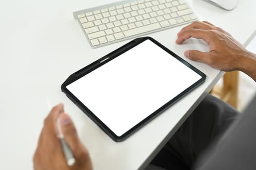 Close up shot businessman using digital tablet at office desk.