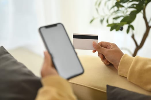 Woman making an online purchase with credit card and smartphone.