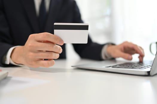 Businessman making a purchase or payment with credit card online.