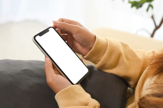 Close up person holding smartphone with white screen for app display.