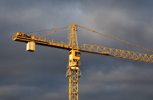 Construction boom in western Ukraine. Sunset light highlights crane and buildings in a city under development.