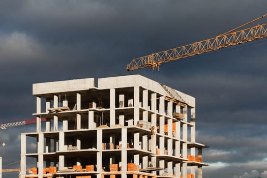 Construction boom in western Ukraine. High-rise buildings under construction, featuring unfinished concrete and brick structures.
