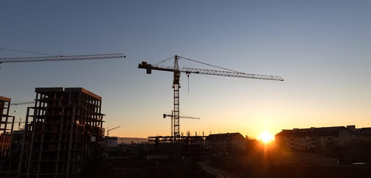 Construction boom in western Ukraine. A construction crane silhouetted against the warm glow of an early morning sky.