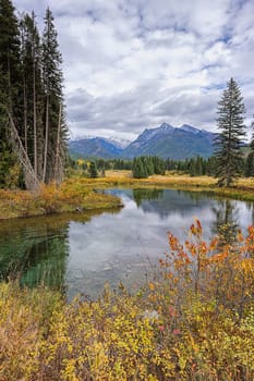 The calm Mirror Pond under a partly cloudy sky along highway 56 in western Montana.
