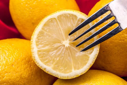 A cross section of a lemon in a basket and a fork.