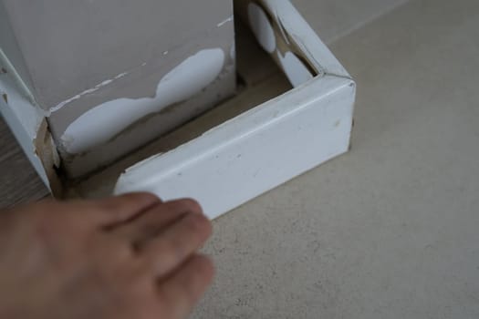 woman hand show damaged by humidity skirting base board on corner. High humidity wet place home . High quality photo