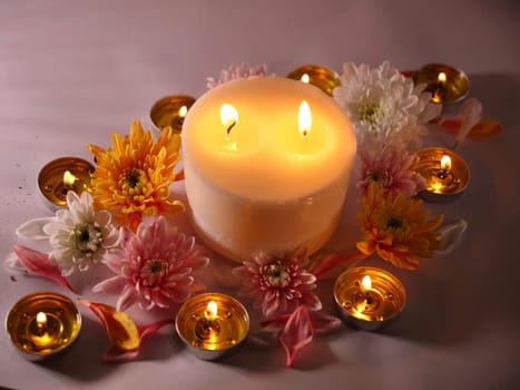 Celebration of Diwali or Deepavali holiday in India with candles and flowers in the evening at night close-up. Hindus celebrate the festival of lights,