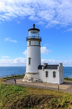 A female tourist stands by the North Head lighthouse in Ilwaco, Washington.