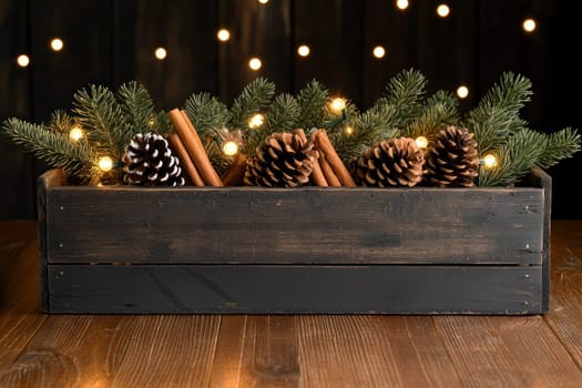 Rustic Christmas decoration with pinecones, cinnamon, and lights.