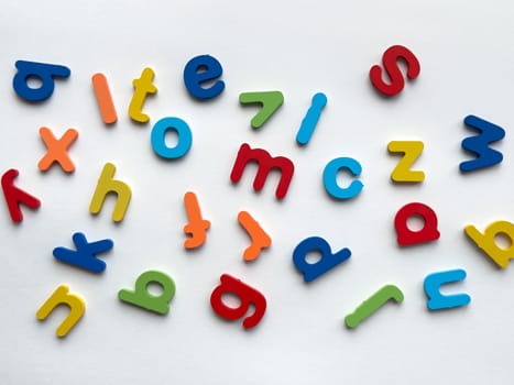 Colorful wooden letters on white background.