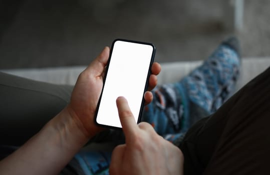 Close-up of male hands holding modern smartphone. Guy flipping news on cellphone or chatting with friends. Copy space on blank screen of phone. Electronic devices concept