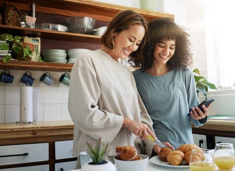 Lgbtq, couple and women with smartphone and cooking with happiness in kitchen for breakfast or nutrition in morning. Food, people and home with romance and lesbian or natural face for care or love.