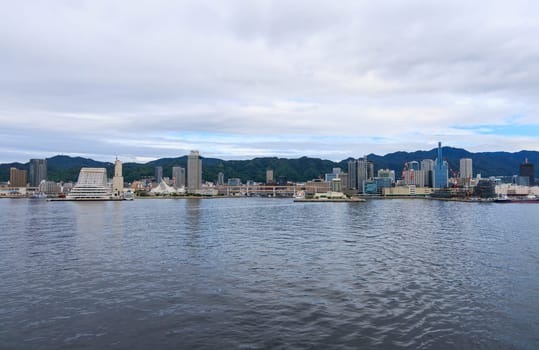 Kobe, Japan - September 23, 2023: View from water of Kobe City and harbor on cloudy day. High quality photo