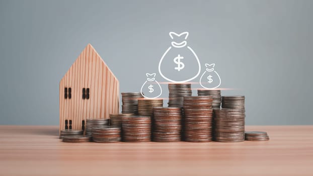 Model wooden house and coins lined up on wooden floor on white background. Concepts of finance, savings and investment. Real estate concepts.