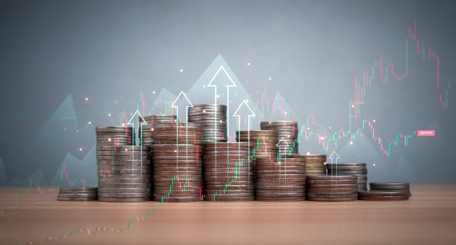 Coins are lined up on a wooden floor along with index charts, arrows and candlesticks. Represents financial, economic, business growth concepts. Financial success concept. Abstract finance background.