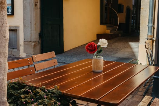 Empty cafe terrace with white table and chair. exterior of the cafe restaurant. interior Street cafe. Cozy street with flowers and French-style cafe table. Decor facade of coffeehouse with bike. Table on a summer terrace with cake and teapot. Garden table and chairs