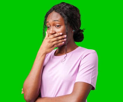 Young woman expressing surprise with her hand covering her mouth against a bright green background in studio
