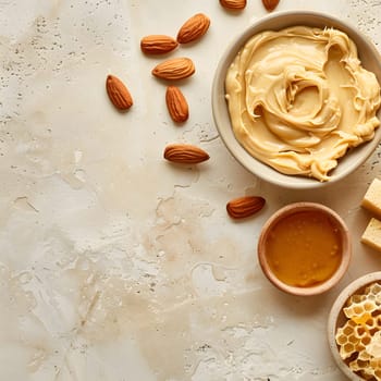 Smooth almond butter and honey with fresh almonds and honeycomb on light background.