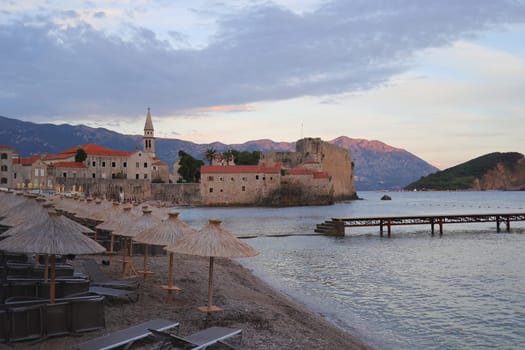 Old mediterranean coastal town with characteristic citadel and walls built for protecting the city from raiders and pirates. View from the beach area.