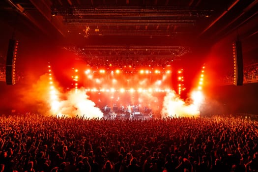 The stage during a concert is lit with bright red light and floodlights. High quality photo
