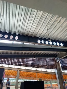 A detailed view of an industrial ceiling featuring intricate brick patterns and a modern pendant light. The design combines steel beams and woven textures for an urban architectural look.