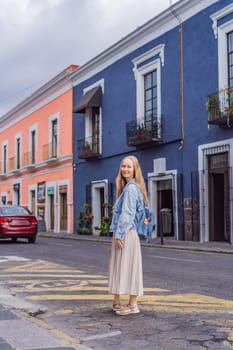 Female tourist walking through the colorful colonial streets of Puebla, Mexico. Travel, cultural exploration, and vibrant architecture concept.