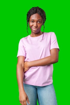 Young woman with curly hair shows a skeptical expression against a bright green background in studio