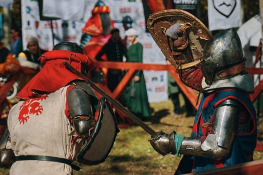 Reconstruction of medieval jousting matches. Battle of two knights from different historical clubs in the arena. Sword fighting. Bishkek, Kyrgyzstan - October 13, 2019