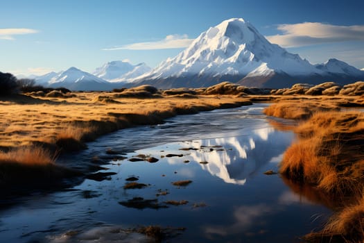 Snow-capped mountain reflecting in a peaceful stream, surrounded by golden grass.
