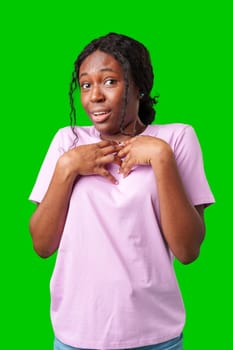 Surprised young woman against a vibrant green background expressing astonishment or shock close up