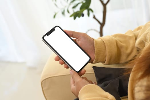 Close up of woman relaxing and holding smartphone with blank display.