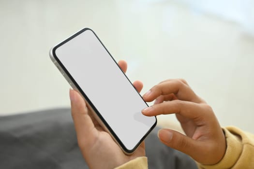 Close up of woman relaxing and holding smartphone with blank display.
