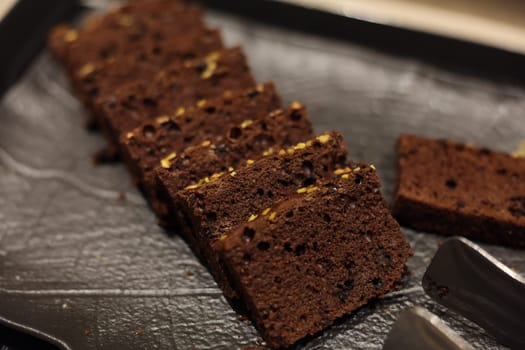 Delicious and tempting slices of rich chocolate cake are beautifully presented on an elegant dark platter