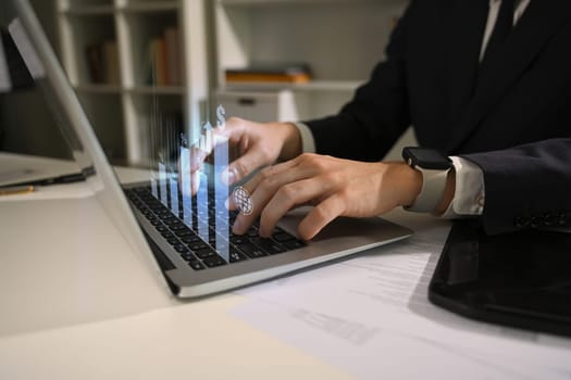 Hands of professional businessman working on financial data with virtual charts.